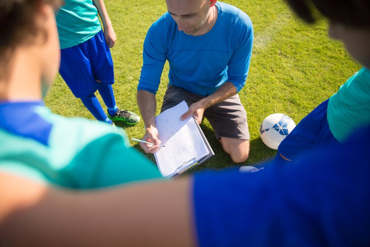 services-img-03 Coach instructing young soccer players during a practice session in Portugal.